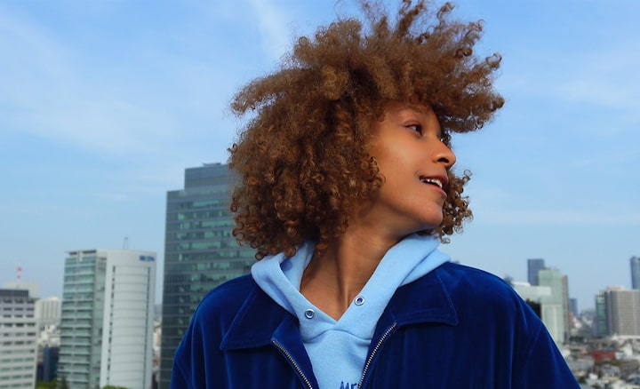 Image of a model in the city with buildings in the back